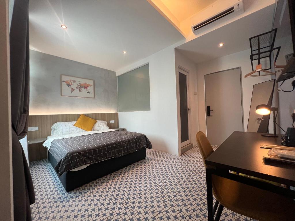 a hotel room with a bed and a desk and a table at Ninety Guest House in Ipoh