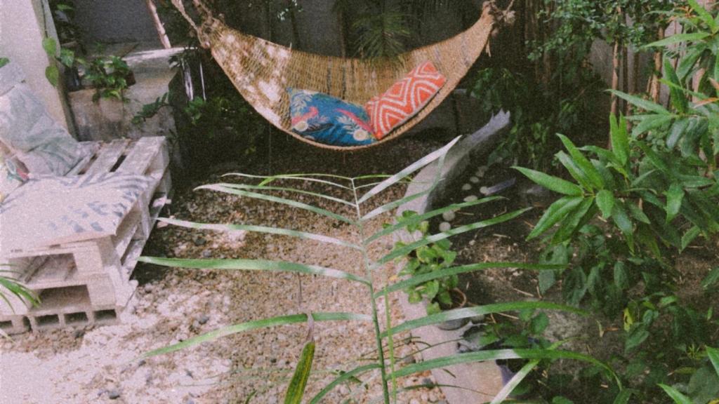 a hammock in the middle of a garden with plants at Boho Inspired Home Near Rockwell in Manila