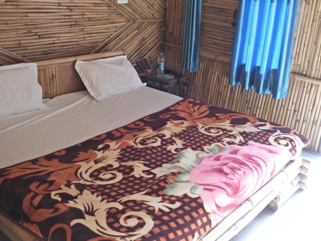 a bedroom with a bed with a blanket on it at Hills Of Adventure, Keshudhar, Lansdowne in Lansdowne