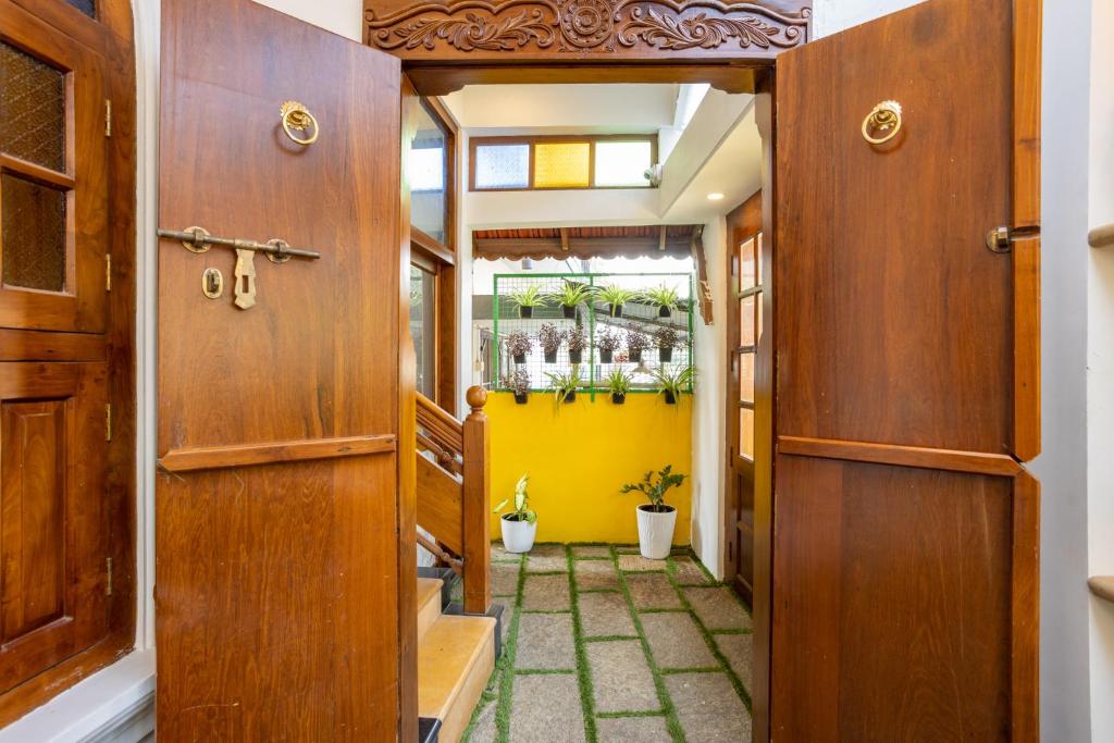 a hallway with wooden doors and a yellow wall at The Barracks Cochin in Cochin