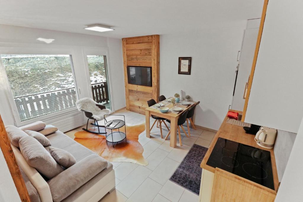 a living room with a couch and a table at Appartement en plein centre de Crans Montana in Crans-Montana