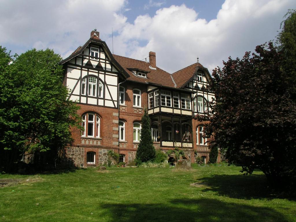 a large brick house with a green yard at Ferienwohnung auf der Rübenburg in Barnsen