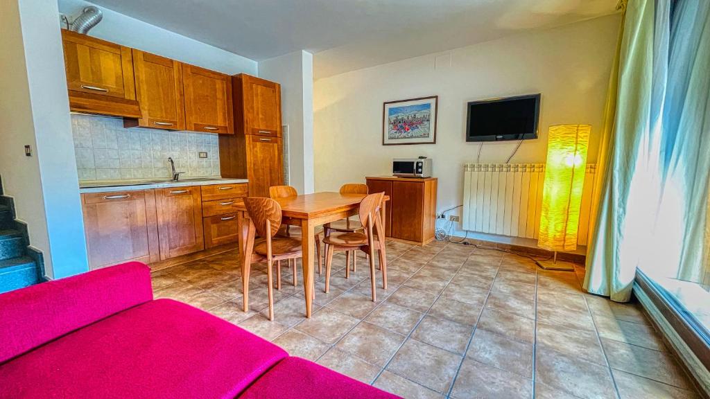 a kitchen with a table and chairs in a room at Appartamento Smith Nebbiolo - Affitti Brevi Italia in Bardonecchia