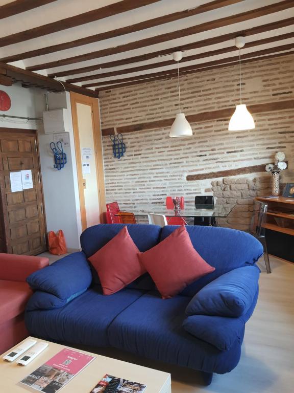 a living room with a blue couch with red pillows at Toledo Flat, City Centre in Toledo