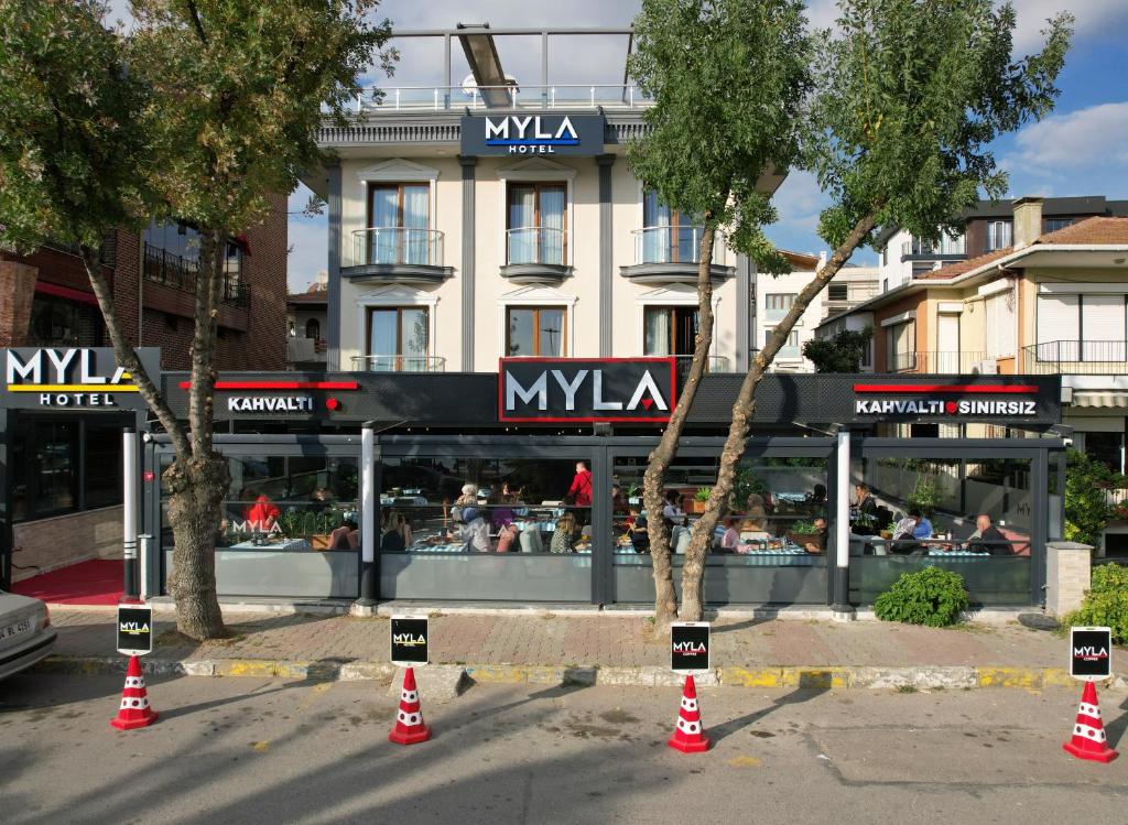 MYLA Hotel Tuzla في توزلا: مطعم امام مبنى به مخاريط برتقالية