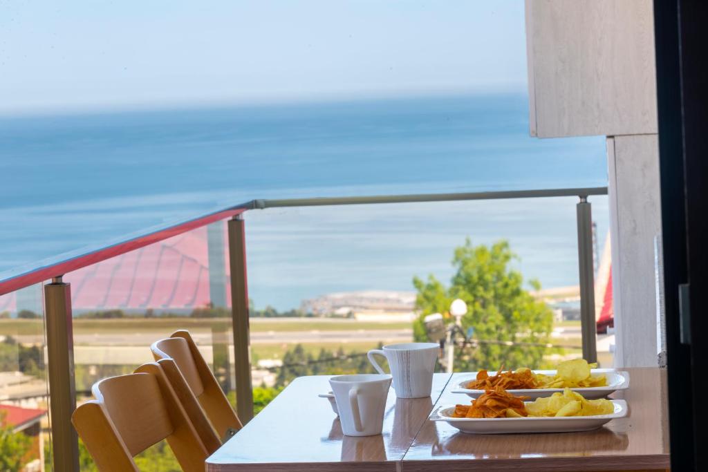 a table with a plate of food on a balcony at Fera Life Suit Apart in Trabzon