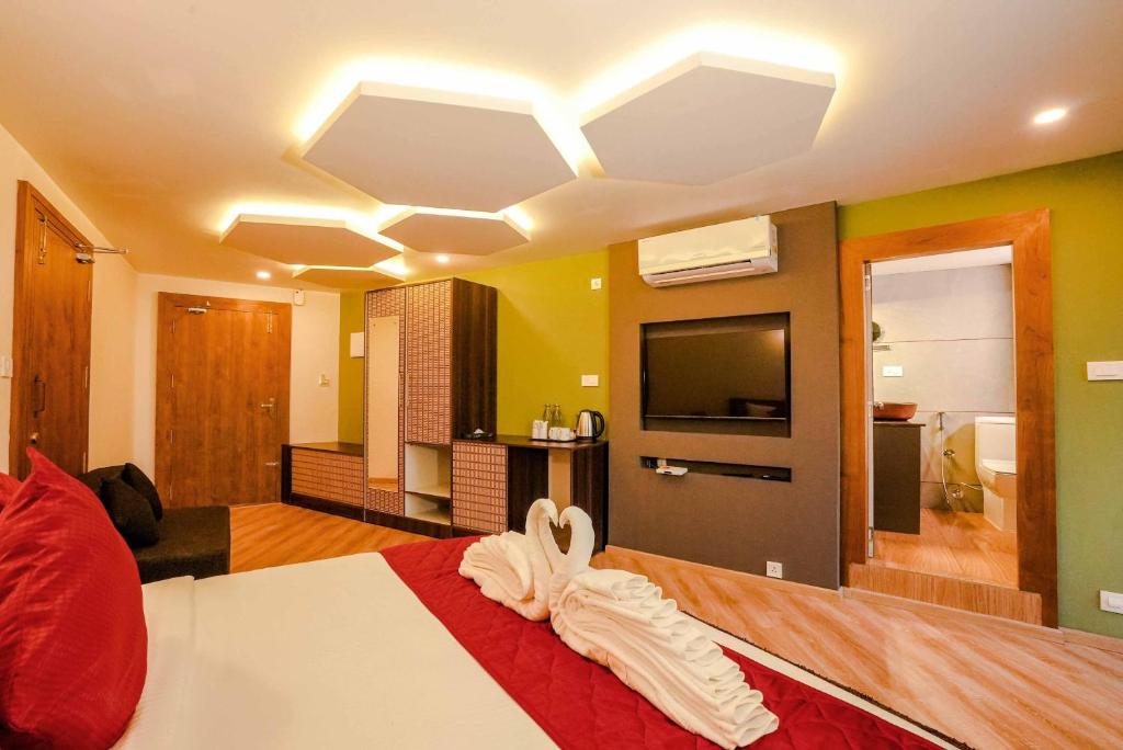 a hotel room with a bed and a television at Kuruva Island Resort And Spa - By KABINI BREEZE, Wayanad in Mananthavady