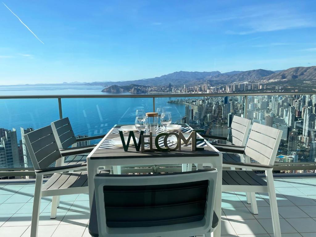 einen Tisch und Stühle auf einem Balkon mit Aussicht in der Unterkunft Gran lujo, terraza grande y vistas al mar - planta 41 in Benidorm