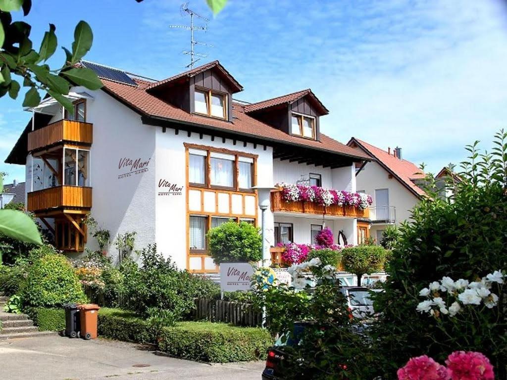a white house with flowers in front of it at Hotel Garni Vitamari in Wasserburg