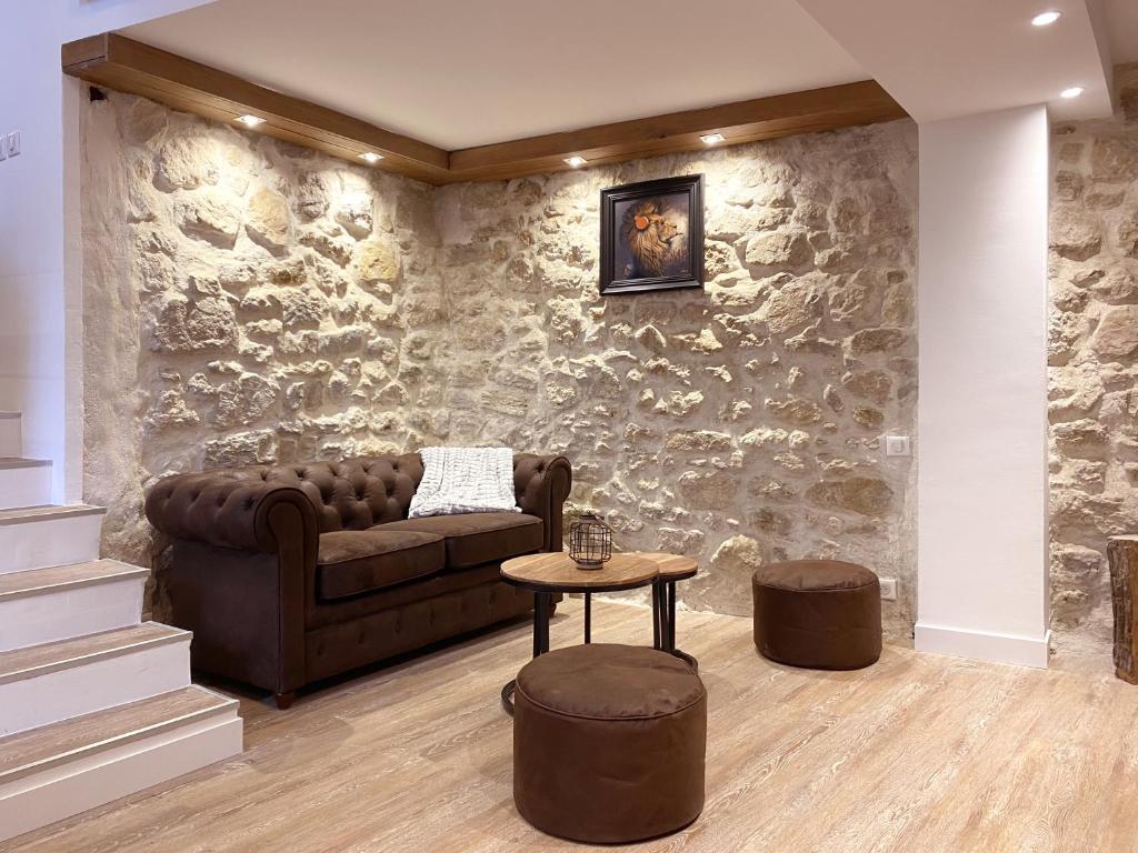un soggiorno con divano e parete in pietra di NEW Maison contemporaine, vieux village de Mougins a Mougins