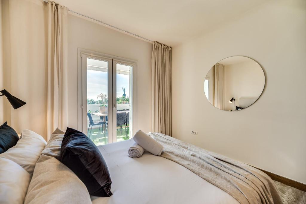1 dormitorio con cama con espejo y ventana en VACATION MARBELLA I Top 1 Puerto Banus Sea Front Rental, Near Marina en Marbella
