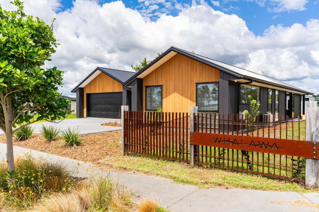 uma casa com uma cerca em frente em Whai Awa Retreat - Mangawhai Holiday Home em Mangawhai