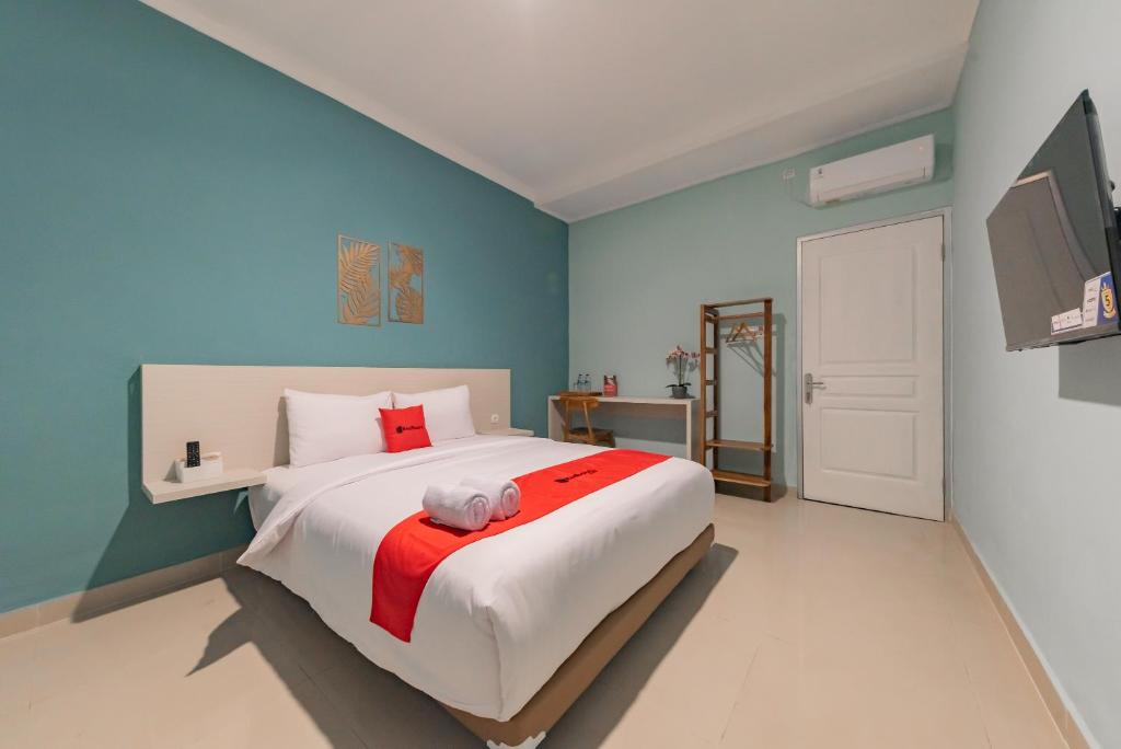 a bedroom with a large bed and a tv at RedDoorz Plus near Surapati Core in Bandung