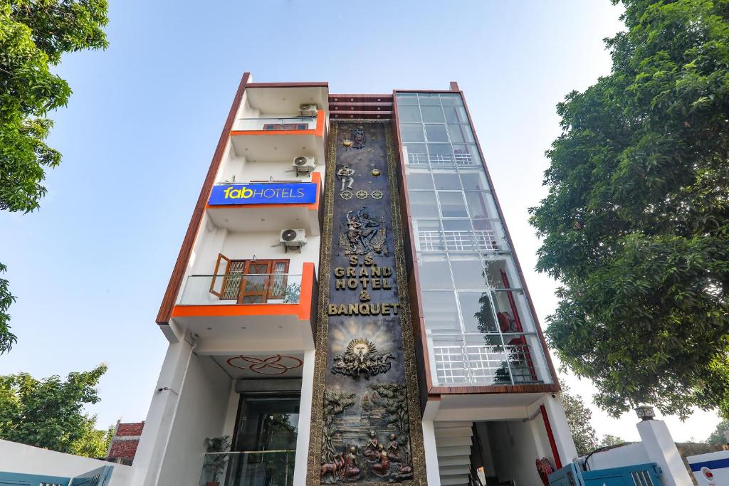 een gebouw met een muurschildering aan de zijkant bij FabExpress SS Grand in Banthra Sikandarpur