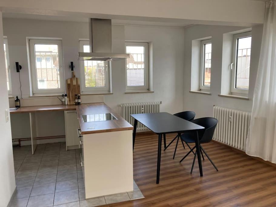 eine Küche mit einem Tisch und Stühlen im Zimmer in der Unterkunft Rooftop mit Fördeblick, zentral & nah am HBF in Kiel