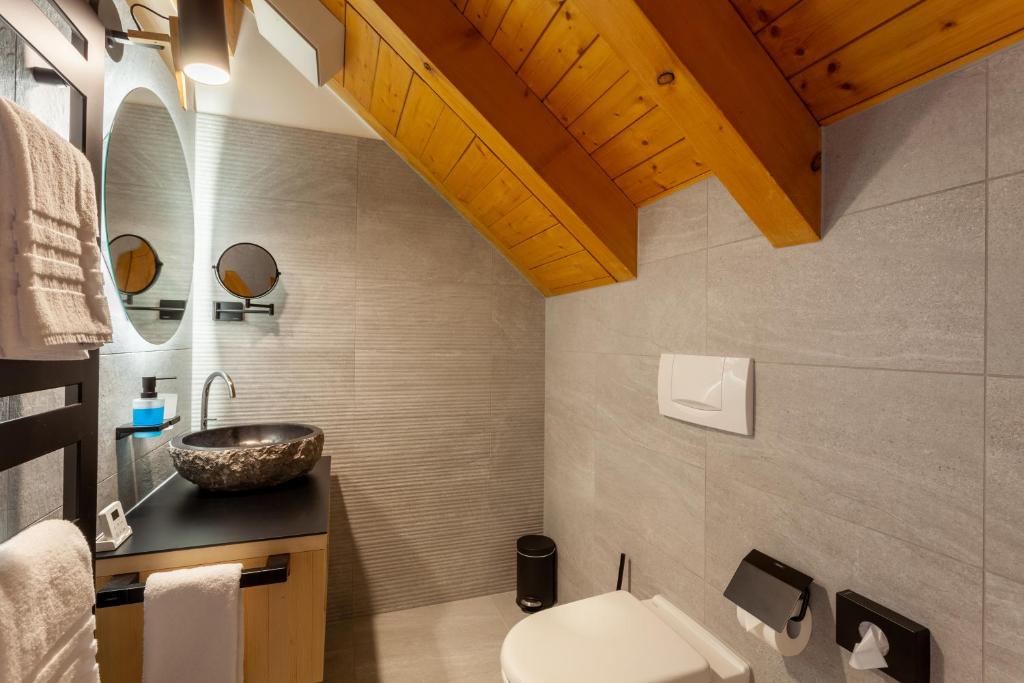 a bathroom with a sink and a toilet at Sonne Andermatt Swiss Quality Hotel in Andermatt