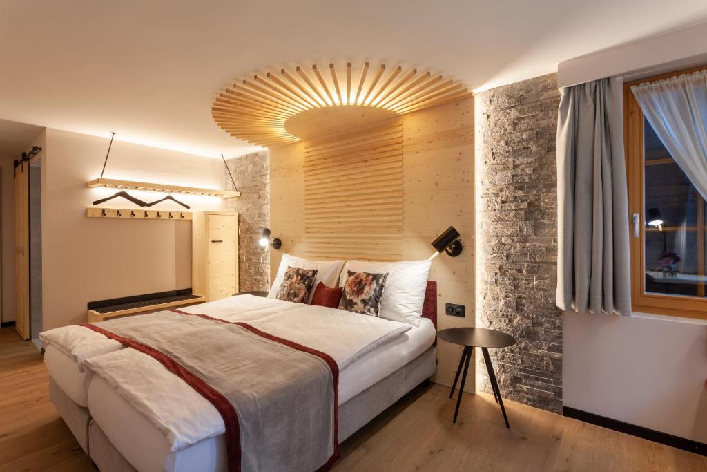 a bedroom with a large bed with a large ceiling at Sonne Andermatt Swiss Quality Hotel in Andermatt
