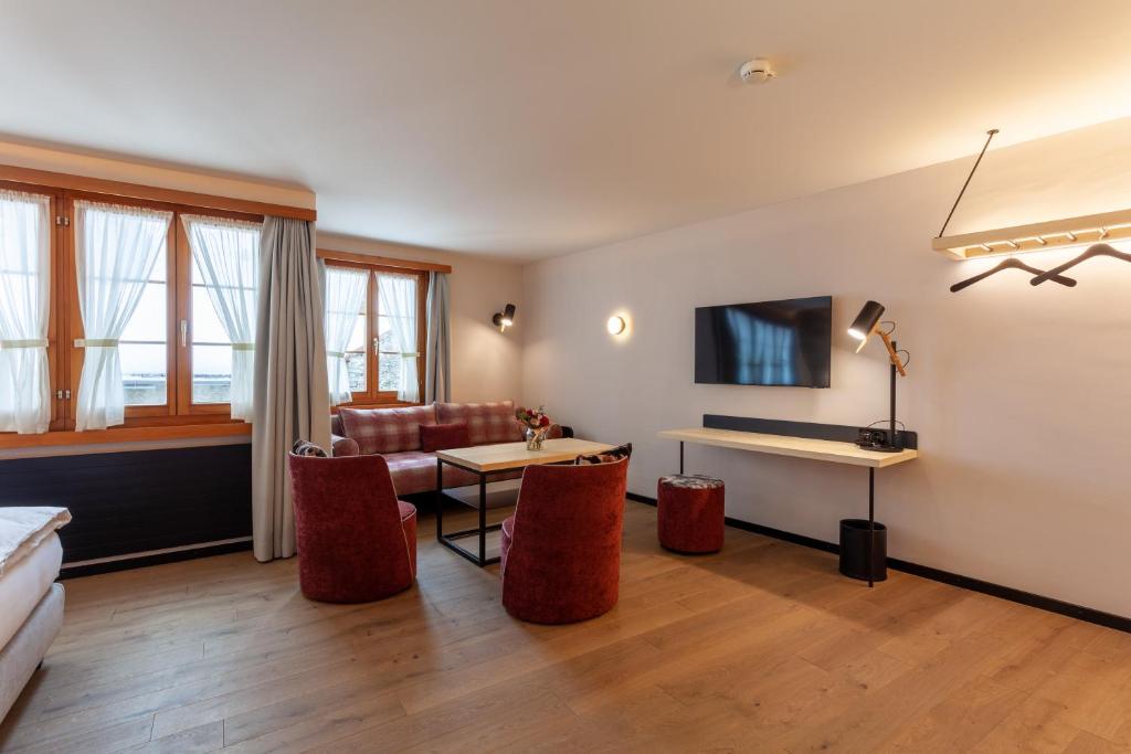 a living room with a couch and a table at Sonne Andermatt Swiss Quality Hotel in Andermatt