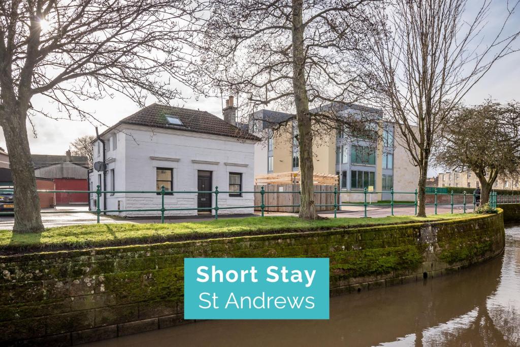 a building next to a body of water at St.Andrews Kinnessburn Road Apartment Sleeps 5 in St. Andrews
