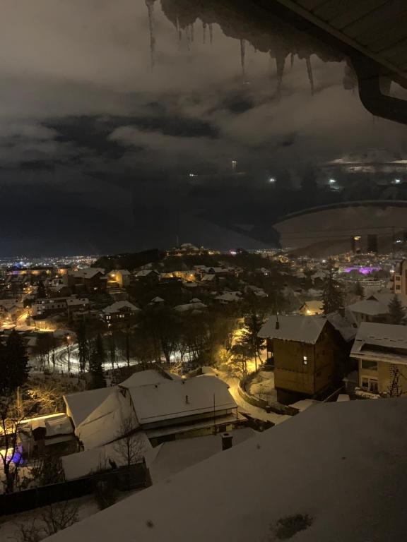 Blick auf eine Stadt im Schnee in der Nacht in der Unterkunft House of Art in Braşov
