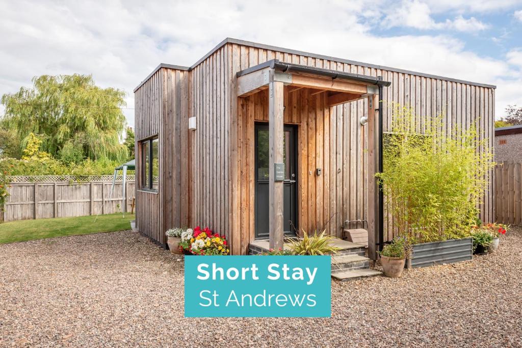 a small wooden shed with the door open in a garden at The Garden House, Free Parking, Central in St. Andrews