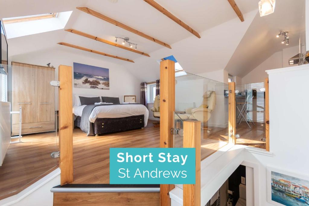a bedroom in a loft stay with a bed and a fireplace at The Old Net Store - Cosy Anstruther Studio Flat in Cellardyke