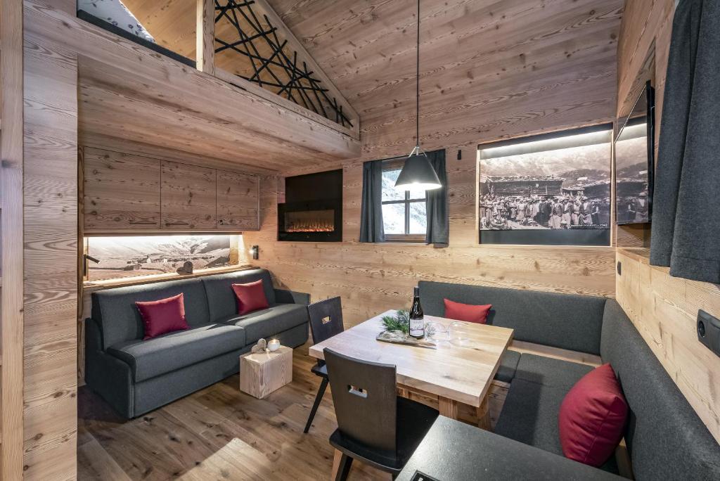 a dining room with a couch and a table at Almhütte Tauber Fane Alm in Valles