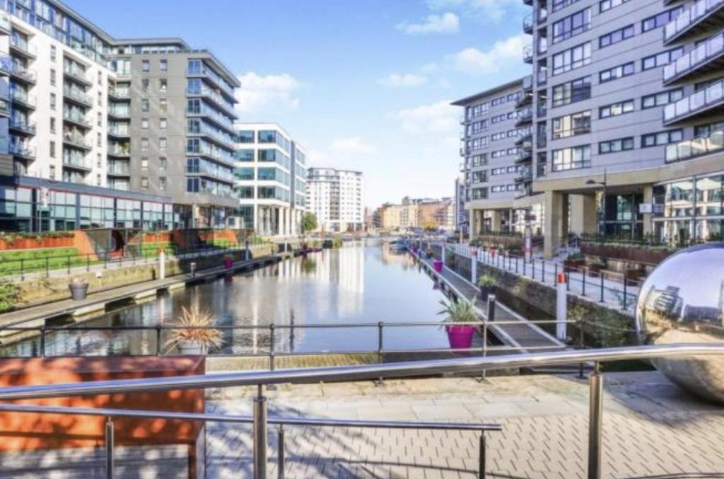 un río en una ciudad con edificios altos en Deluxe City Apt Riverside Balcony &Free Parking, en Leeds