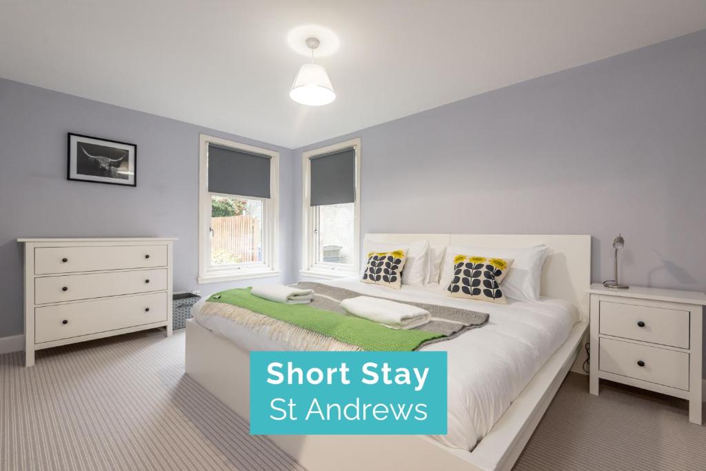 a bedroom with a white bed and two windows at Marine Park - Perfect Elie Base - 1 min to Beach in Elie