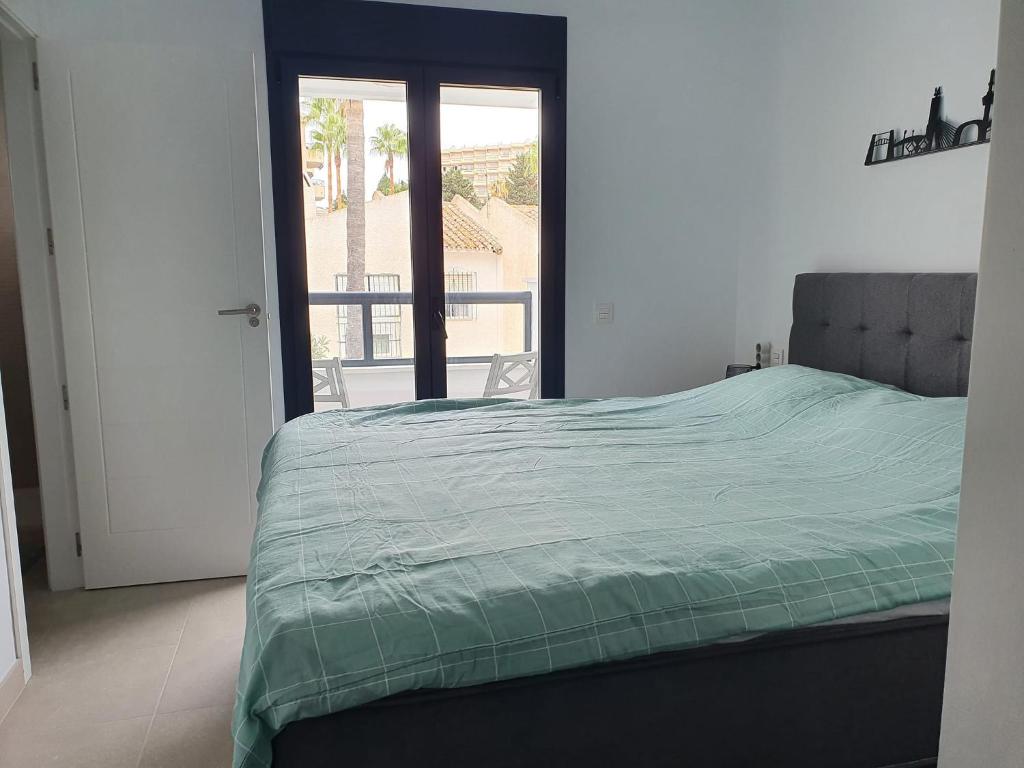 sypialnia z łóżkiem i drzwiami prowadzącymi na balkon w obiekcie Casa Torremolinos w mieście Torremolinos