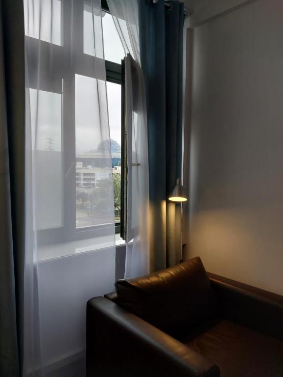 salon z kanapą i oknem w obiekcie Pinto Guest Rooms w Warszawie