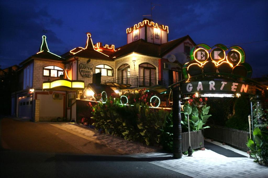 una casa grande con luces encendidas por la noche en Hotel Garten, en Slavonski Brod