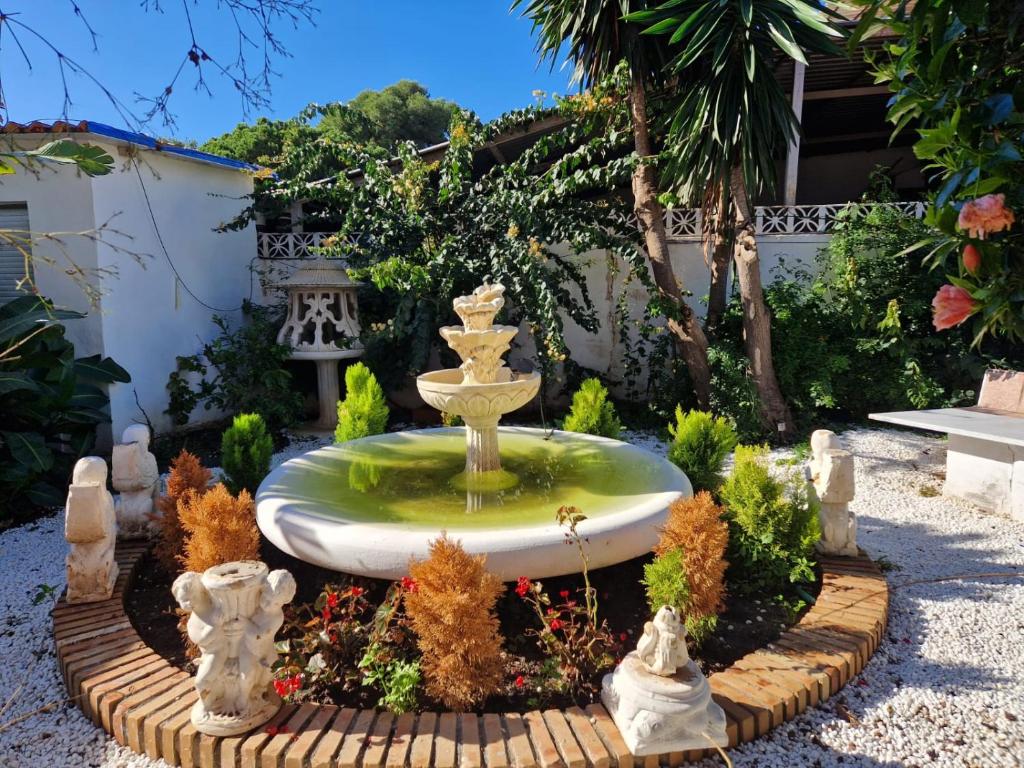 a fountain in the middle of a garden at Villa Costa Marbella in Marbella