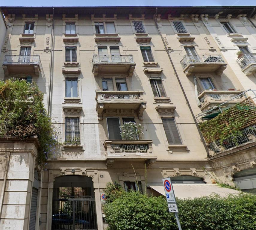 ein großes Gebäude mit Balkonen und einem Schild davor in der Unterkunft Studio Donatello in Mailand