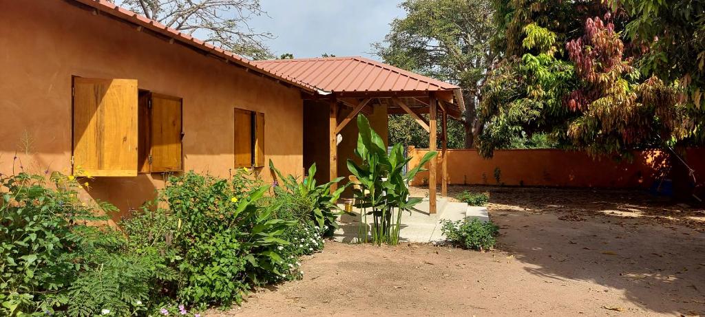 a house with a porch next to a garden at Sénégal CASAMANCE in Boukot Ouolof
