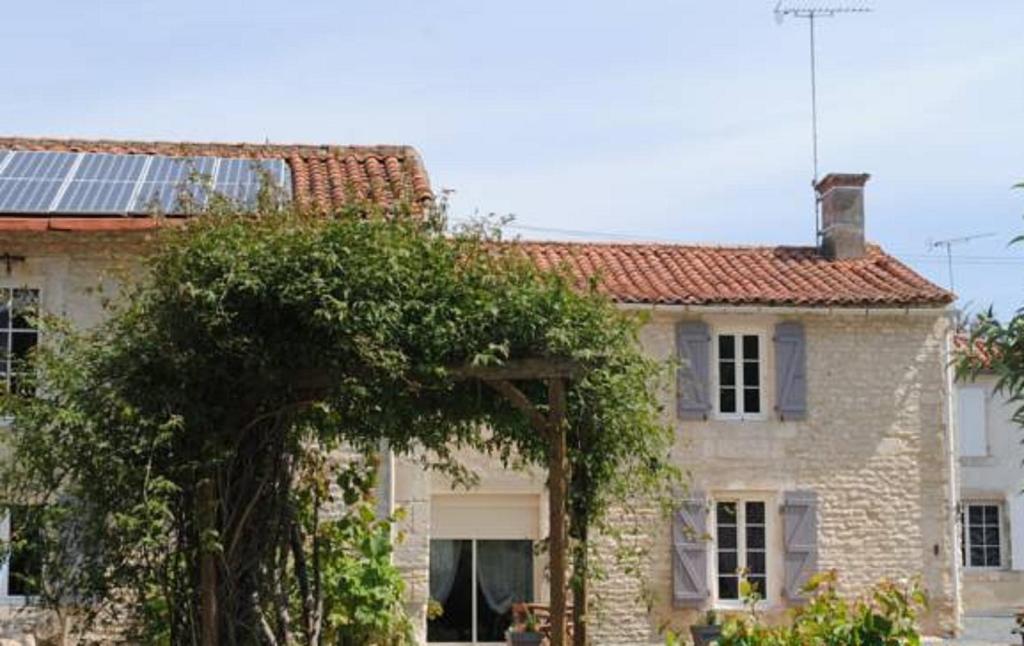 a house with a tree in front of it at La Poussardiere in Saint-Martin-sous-Mouzeuil