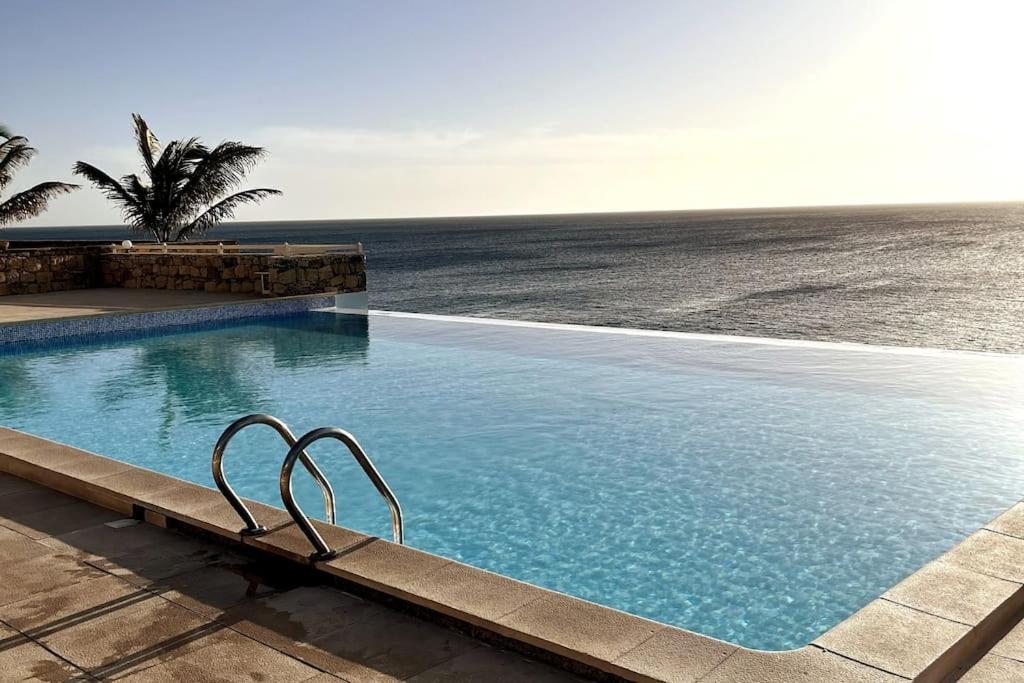 a swimming pool with a view of the ocean at Villa GÊMEO vue mer, piscine accès privé plage in Calheta Do Maio