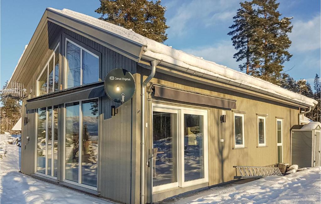 een klein huis met glazen deuren in de sneeuw bij Amazing Home In Brttum With House A Panoramic View in Skrukkerud