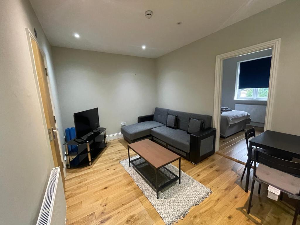 a living room with a couch and a television at Lovely 1 bedroom apartment with on street parking in London