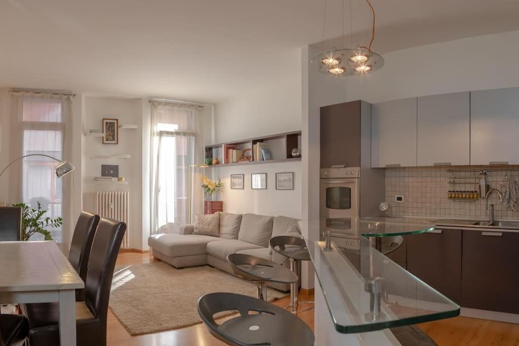 cocina y sala de estar con sofá y mesa en [TridentHome] 5 min from station & free Wifi, en Trento