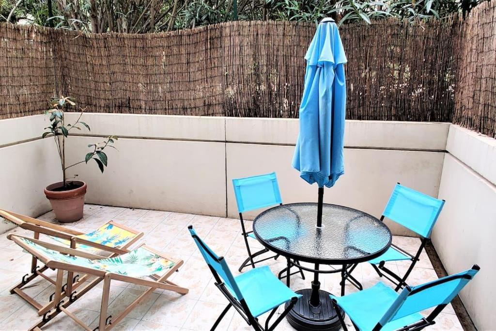 a patio with a table and chairs and an umbrella at Studio avec terrasse en bord de mer Marseille in Marseille