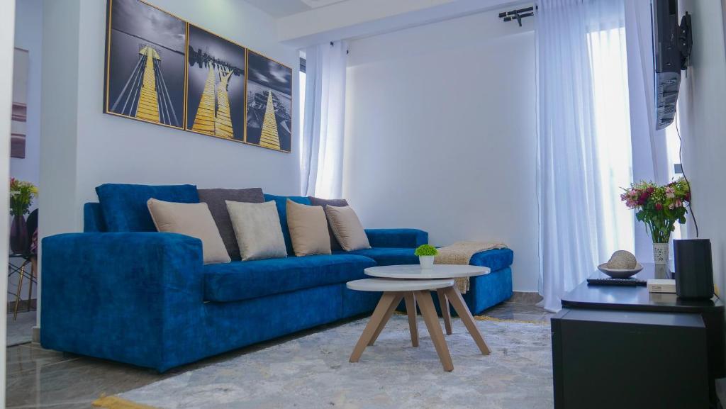 sala de estar con sofá azul y mesa en L&M, en Nairobi