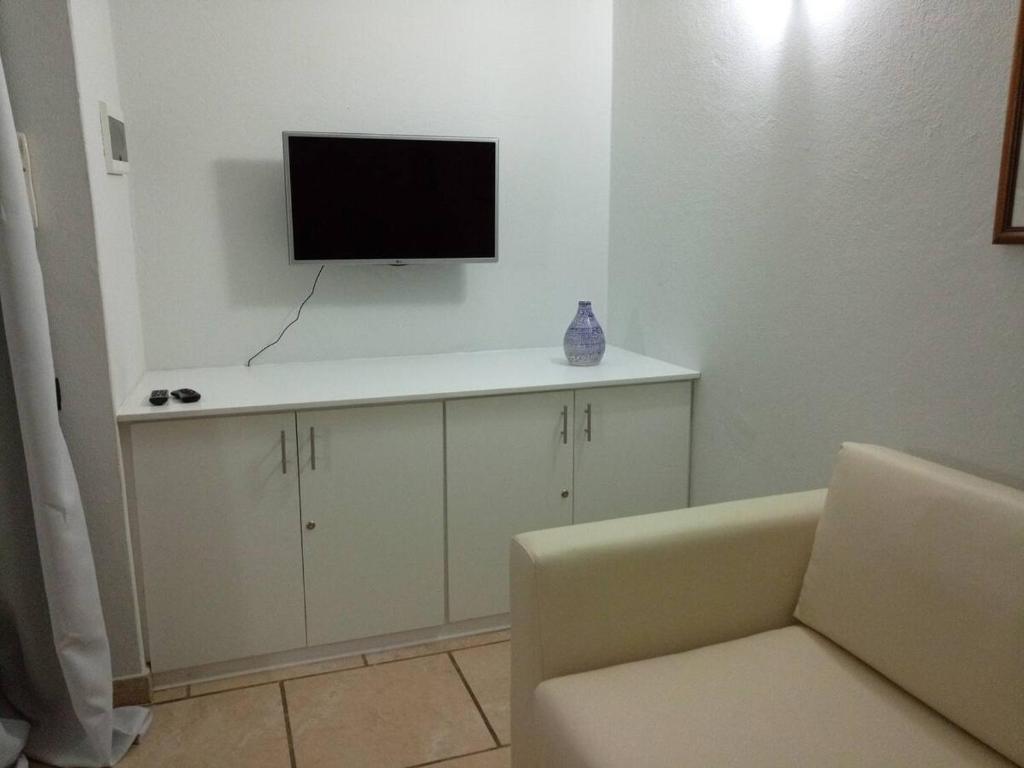 TV a/nebo společenská místnost v ubytování Apartamento Moradias Djadsal C01 próximo à Praia de Santa Maria