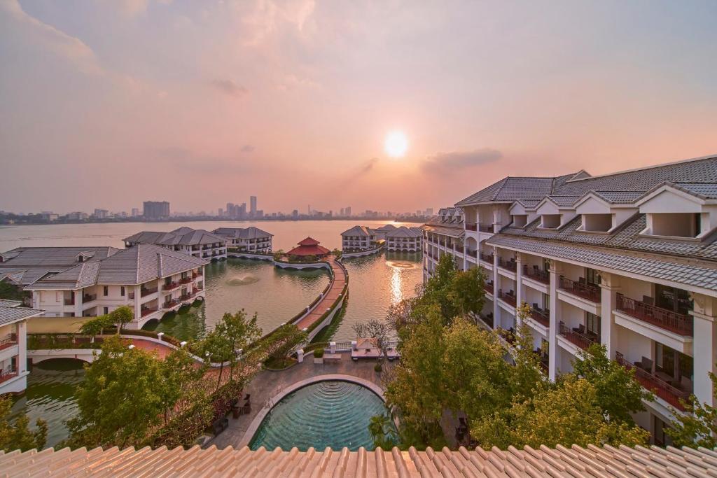 uitzicht op een rivier en gebouwen bij zonsondergang bij InterContinental Hanoi Westlake, an IHG Hotel in Hanoi
