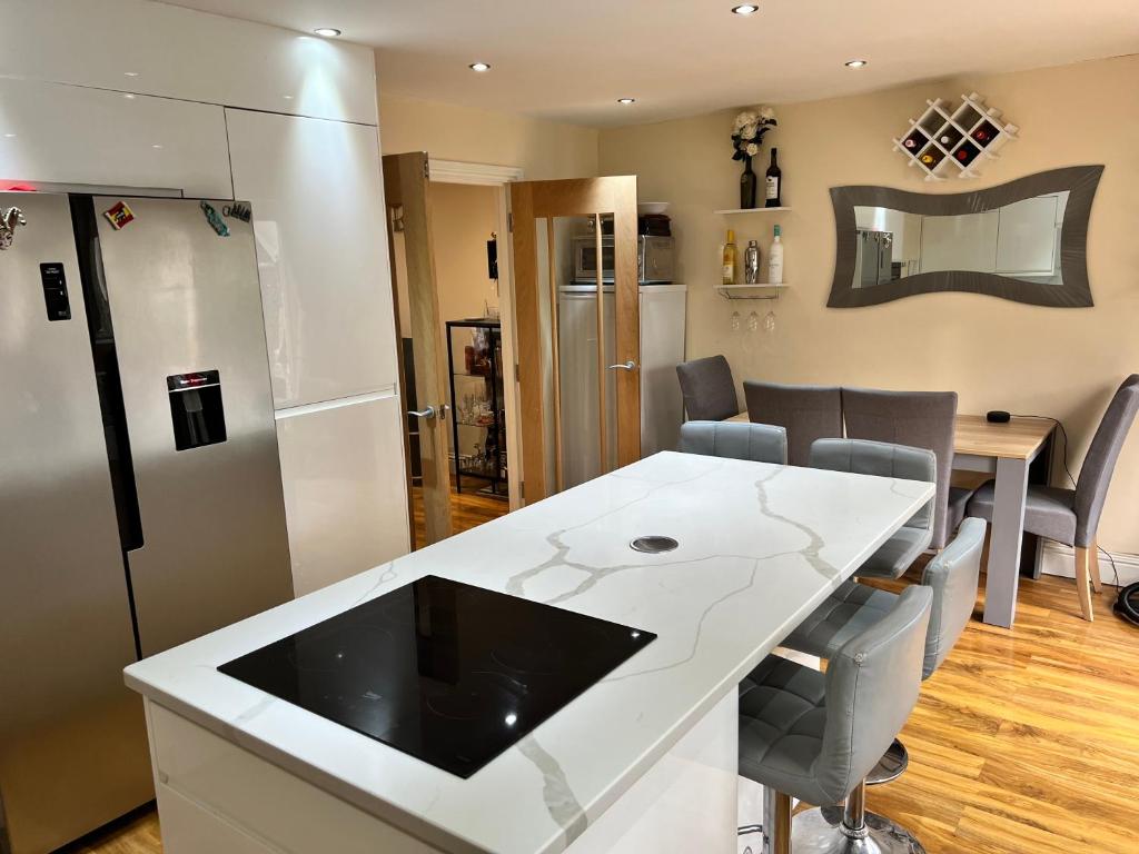 uma cozinha com um balcão branco e um frigorífico em Reading West Homestay em Reading
