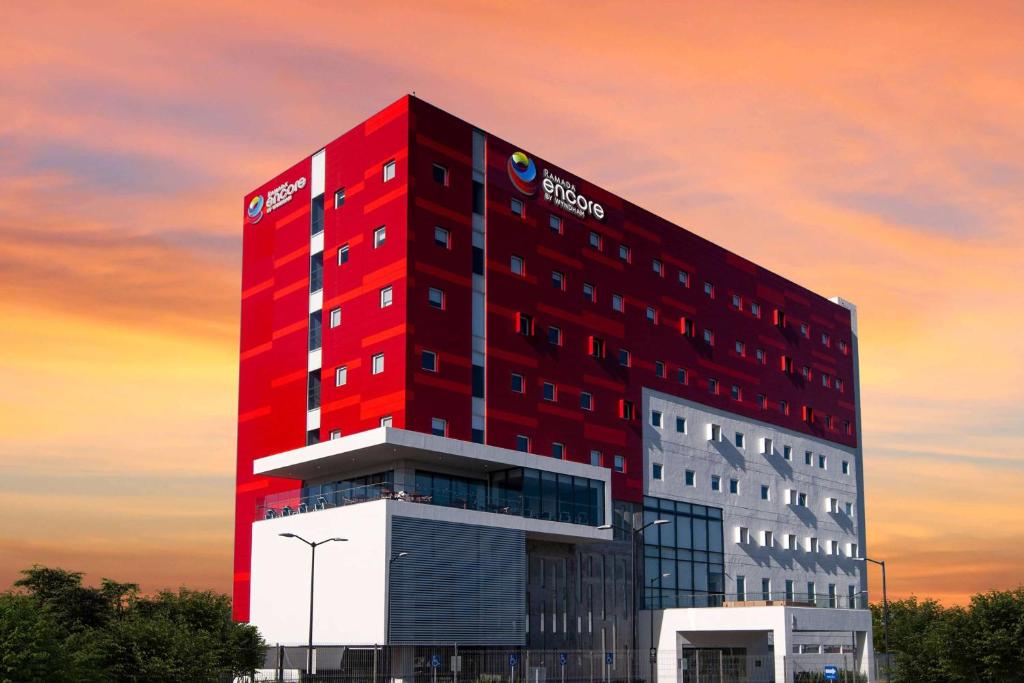 un bâtiment rouge avec un panneau pepsi sur lui dans l'établissement Ramada Encore by Wyndham Guadalajara Aeropuerto, à Guadalajara