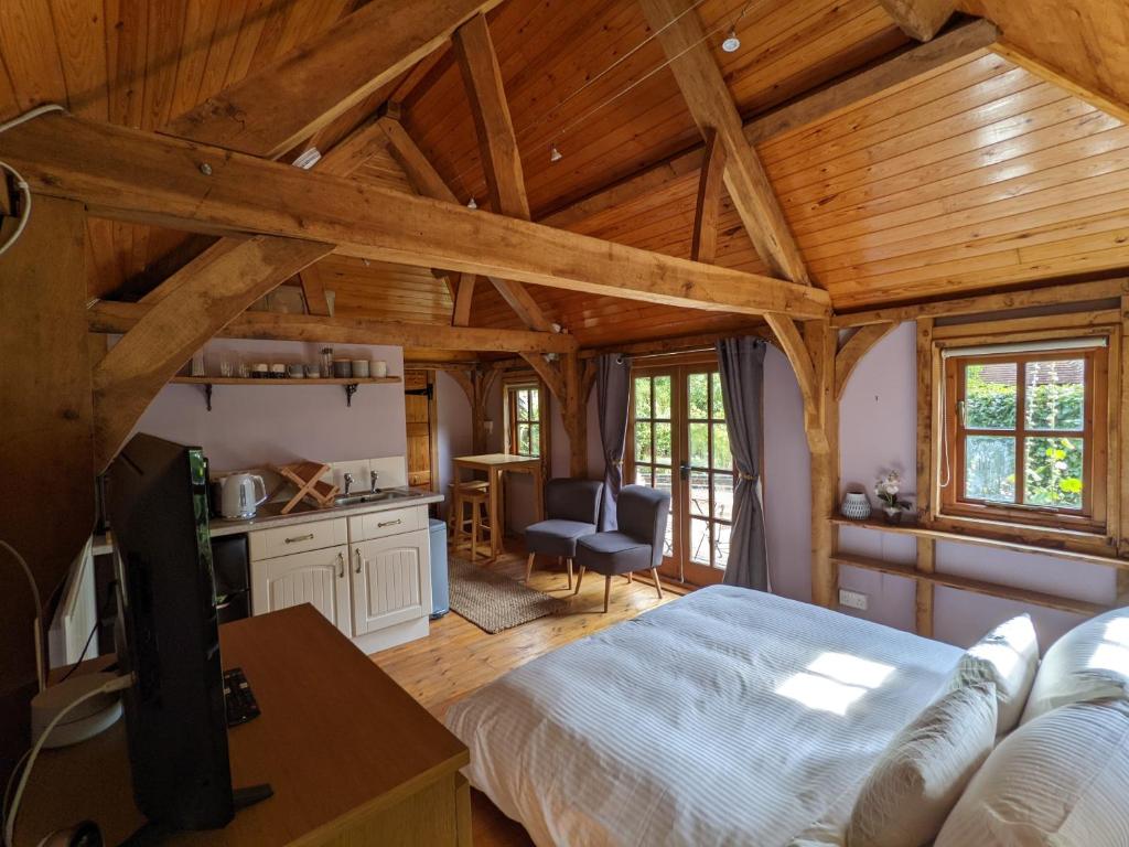 una camera con letto in una stanza con soffitti in legno di Cabin in the Forest a Brockenhurst