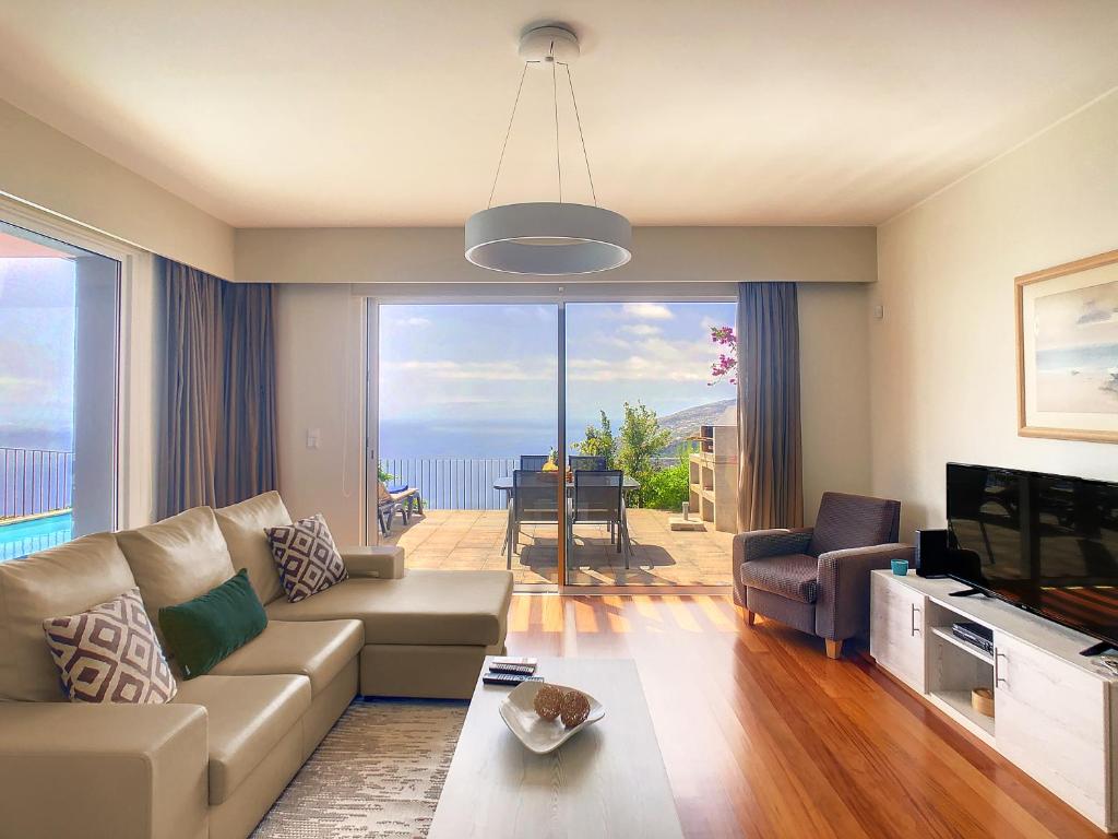 a living room with a couch and a large window at Villa Blue Marlin by LovelyStay in Calheta