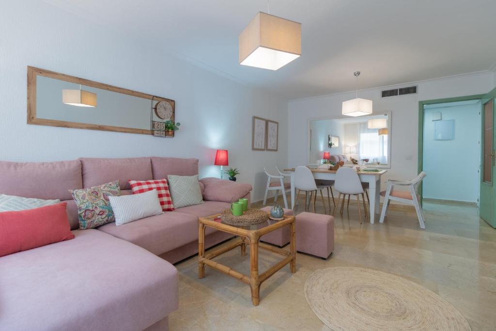 een woonkamer met een roze bank en een tafel bij Apartamento Céntrico Isaura in Córdoba