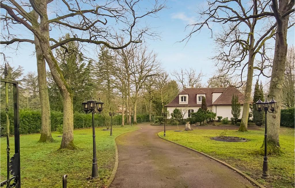 una entrada que conduce a una casa blanca con árboles en Beautiful Home In Lamorlaye With Wifi, en Lamorlaye